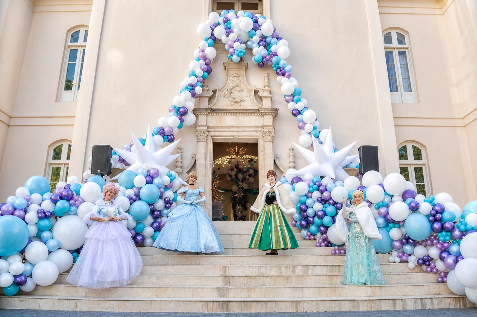 Princess performers beneath a blue, lilac, and white balloon installation at a Poppin Kids celebration
