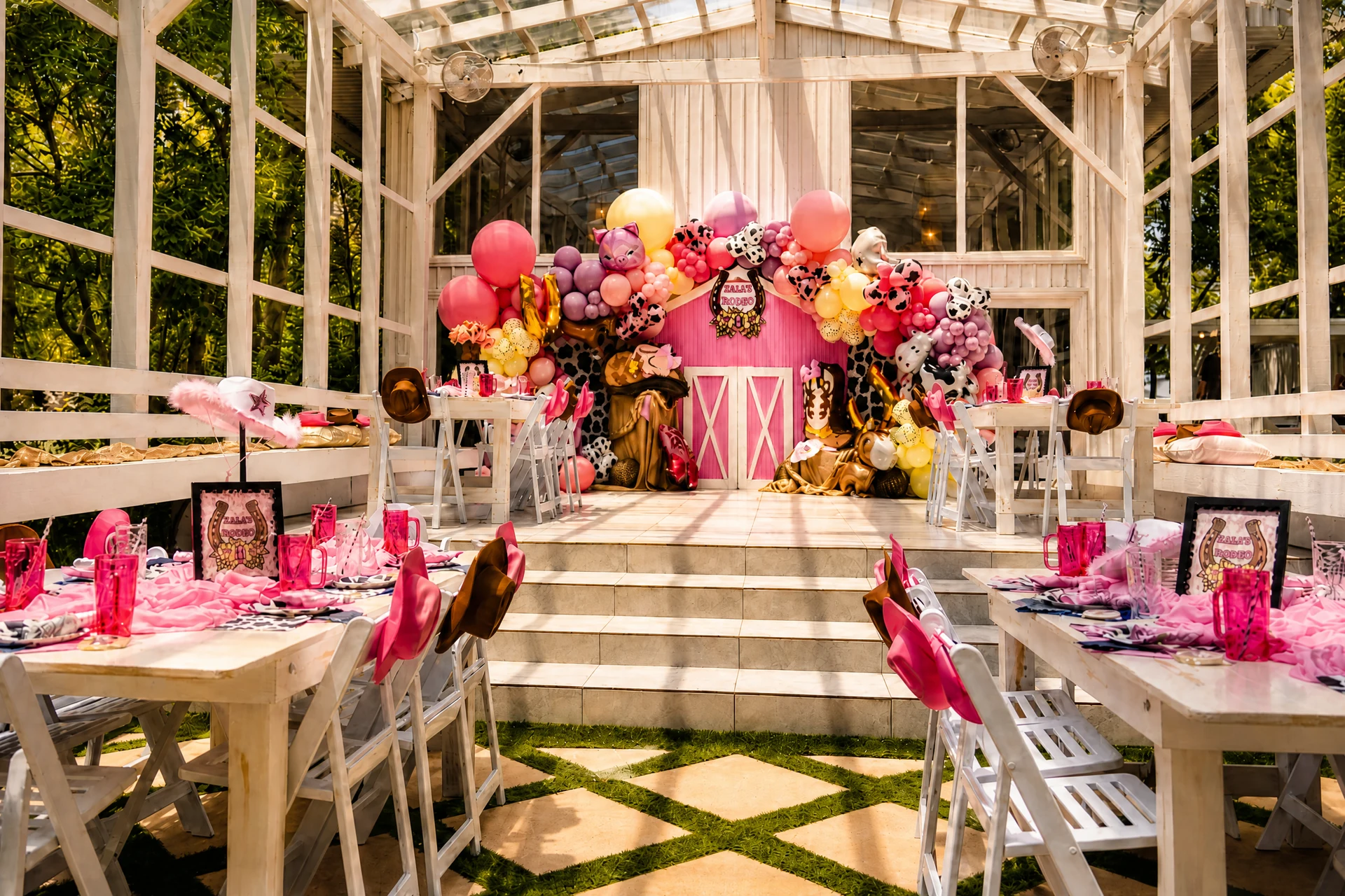 Pink party tent tablescape with floral centerpieces and green patterned flooring